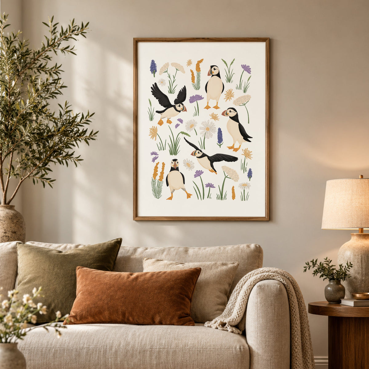 Puffin coastal print displayed above a neutral sofa in a cosy living room with soft earthy tones and cottage-inspired decor.