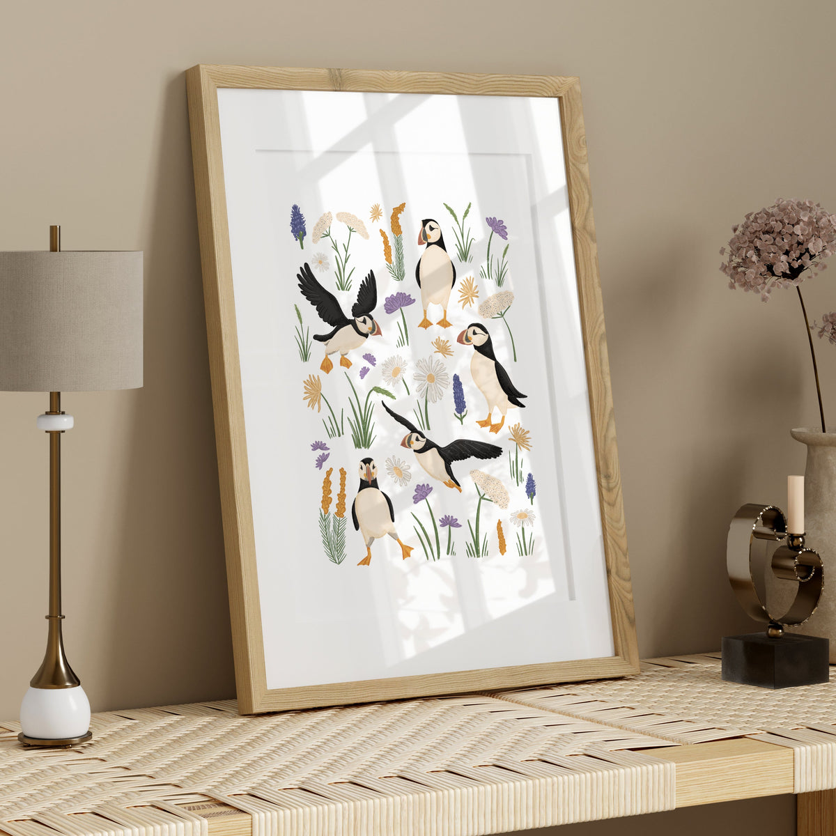 Puffin coastal art print with hand-drawn seabirds and soft botanical details displayed in a light wood frame with neutral styling.