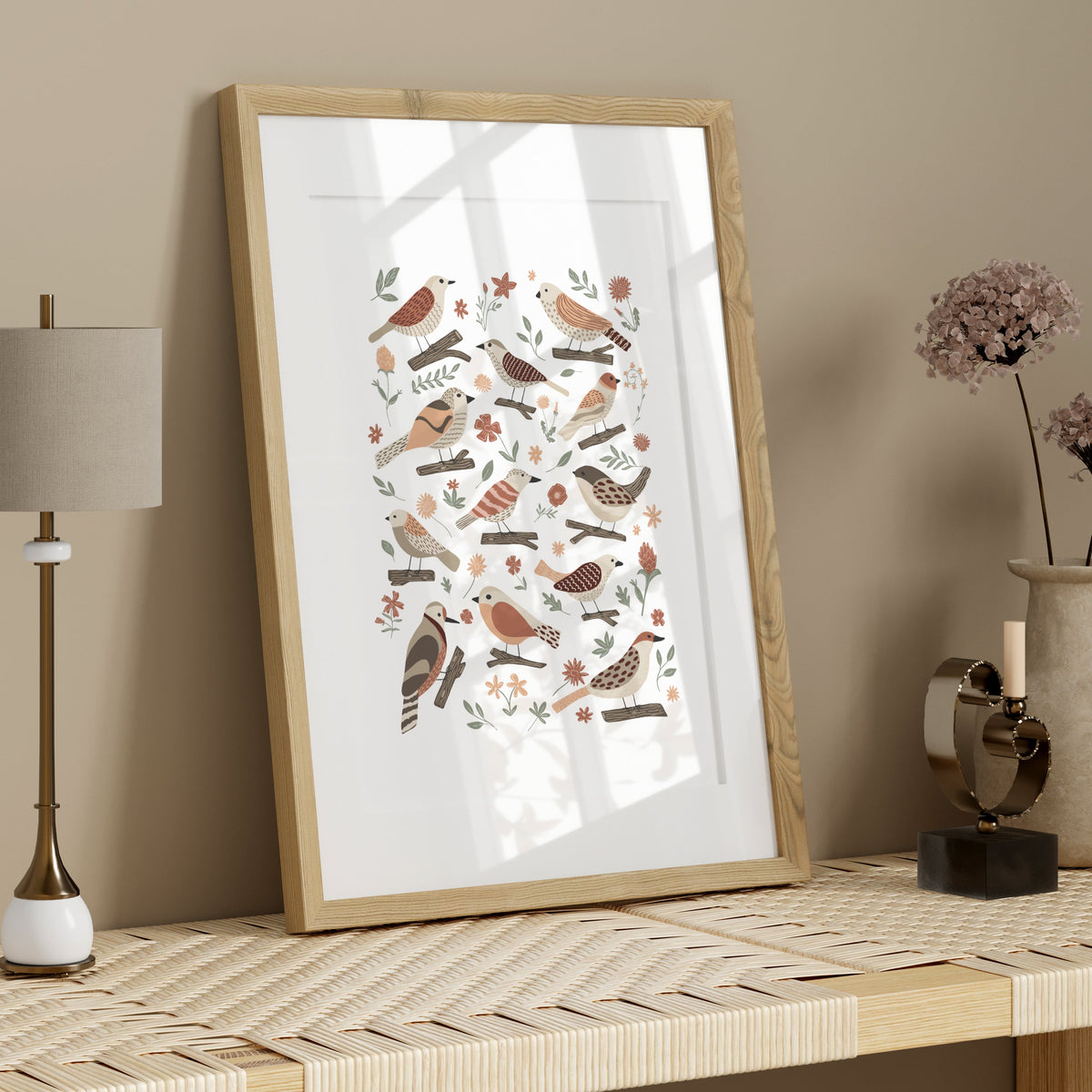 Hand-illustrated garden bird print in a light wood frame styled on a neutral shelf with simple natural decor.