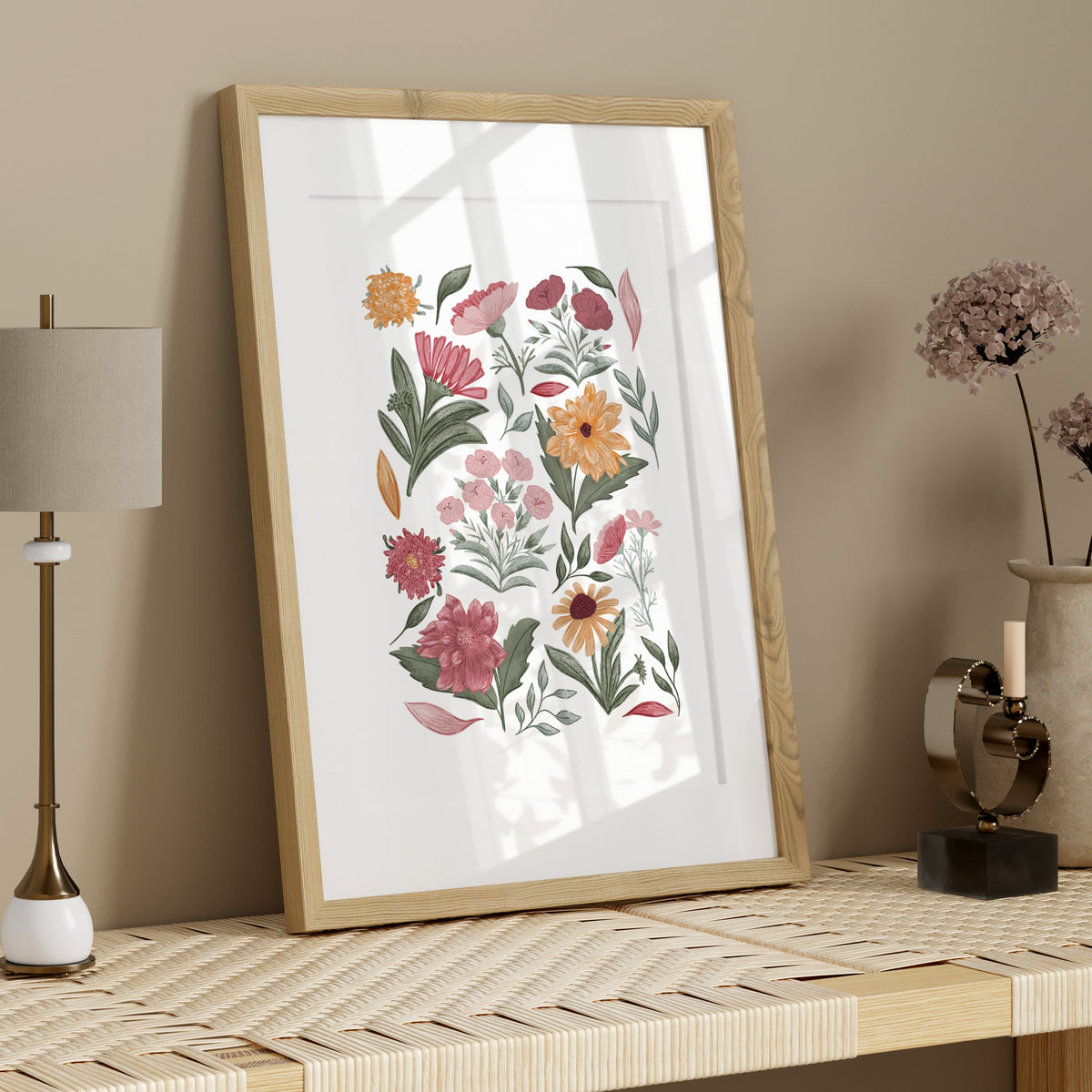 Hand-illustrated floral art print in a light wood frame styled on a neutral shelf with simple natural accessories.