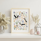 Puffin coastal wall art in a light wood frame styled on a neutral shelf with pottery and soft natural decor.