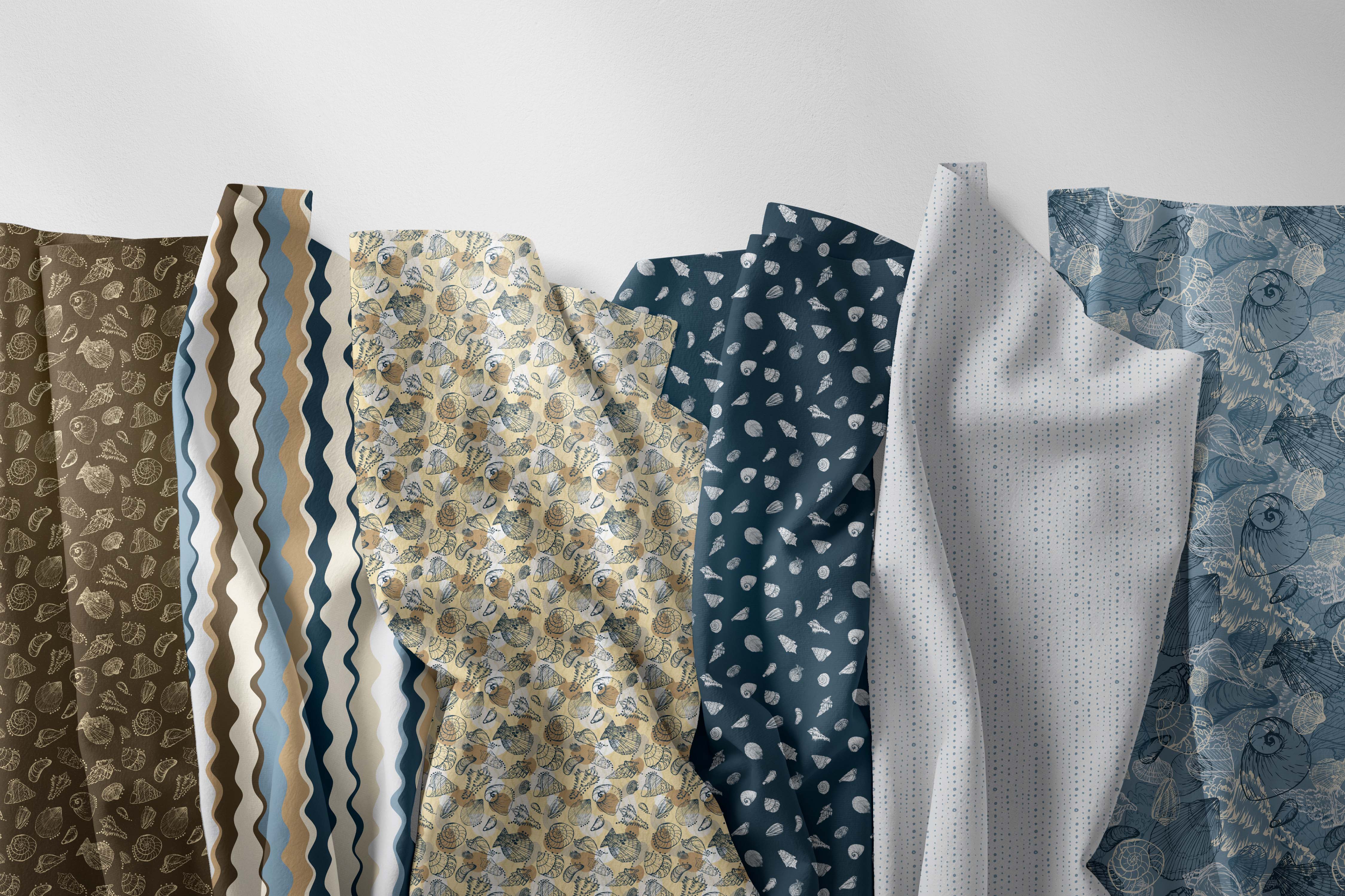 Six different fabric samples with various patterns and colors are draped side-by-side against a plain white background. The fabrics include brown, wavy stripes in blue, beige, and white, a beige floral print, a dark blue leaf pattern, a light gray textured fabric, and a blue floral print.
