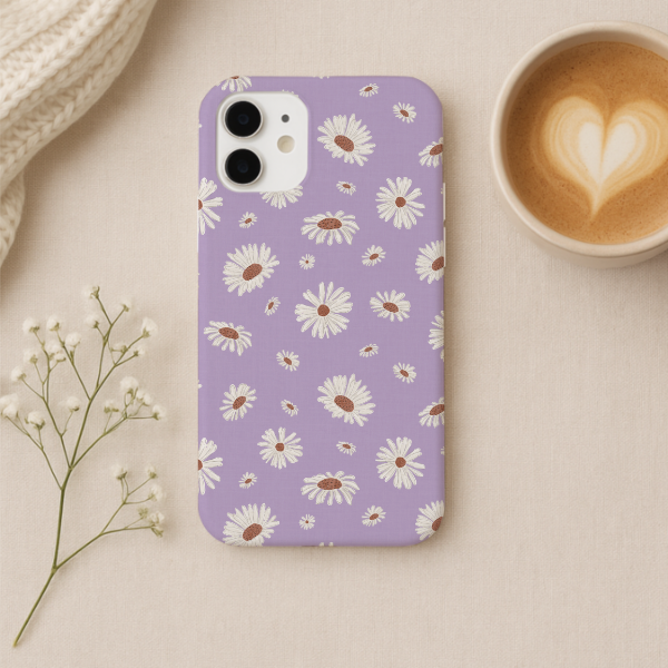 A lavender phone case with a white daisy floral pattern, shown in a styled flat-lay setting next to a cup of latte and baby's breath flowers.