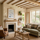 Coastal Christian wall art displayed above a fireplace in a bright living room with exposed wooden beams and neutral furnishings.