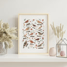 Garden birds art print with hand-illustrated birds, flowers and soft earthy botanical details displayed in a light wood frame.