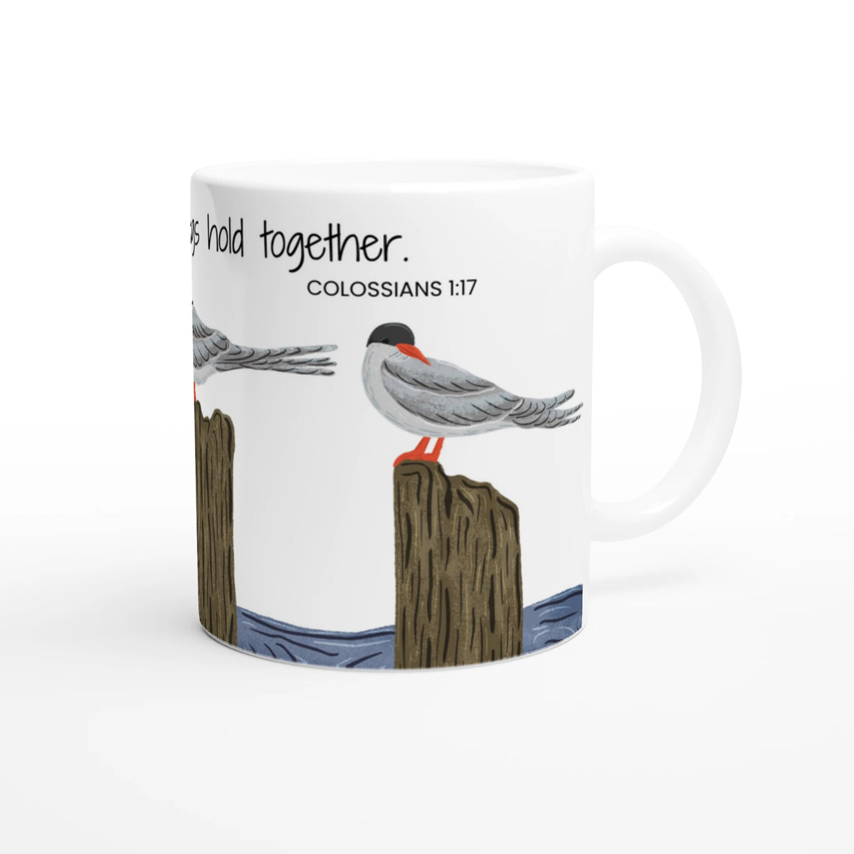 A white ceramic mug featuring an illustration of two seabirds perched on wooden posts with the text 'They hold together. COLOSSIANS 1:17' printed on the side, shown against a plain white background.