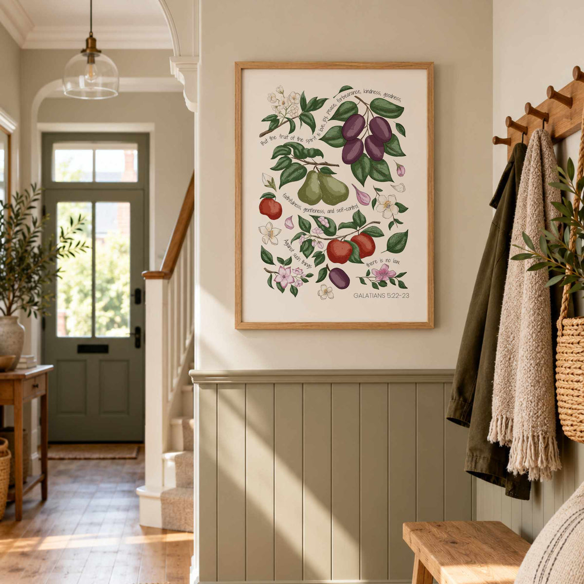 Galatians 5:22–23 scripture print featuring hand-drawn fruit and leaves displayed in a warm neutral hallway.