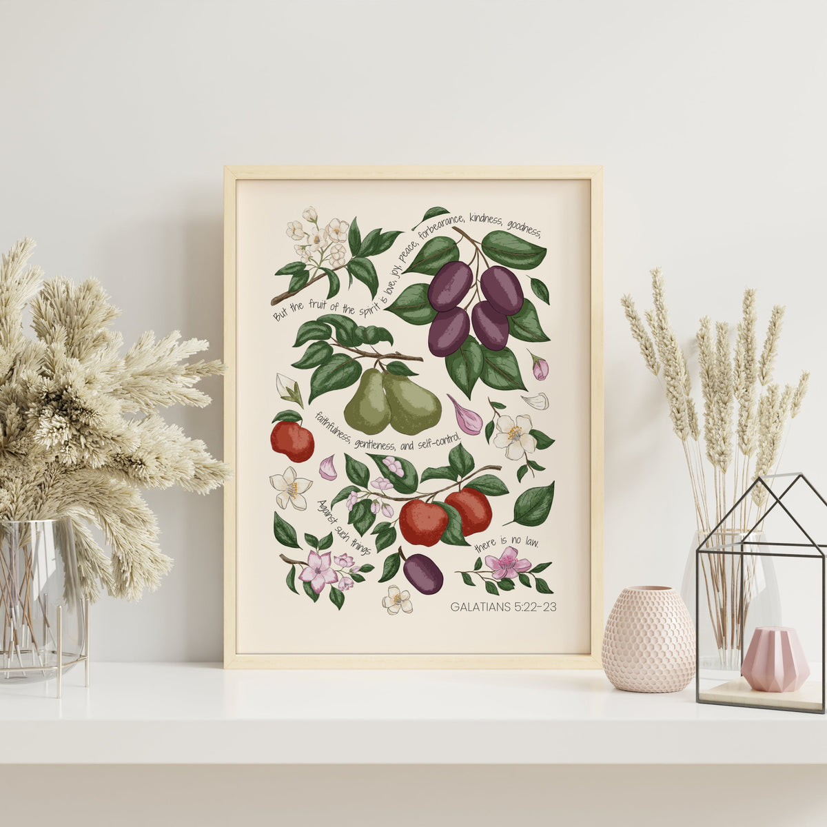 Fruits of the Spirit Christian art print with orchard fruits and botanical foliage displayed in a light wood frame with soft neutral styling.