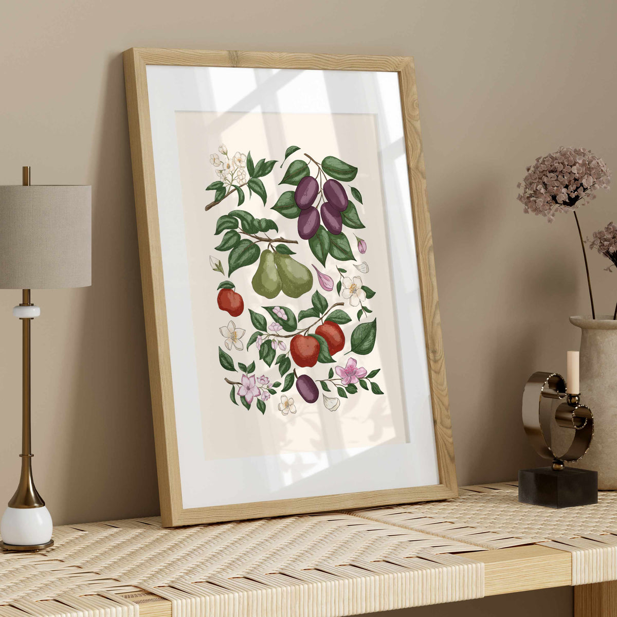 Botanical fruit print in a light wood frame styled on a neutral shelf with simple natural decor.
